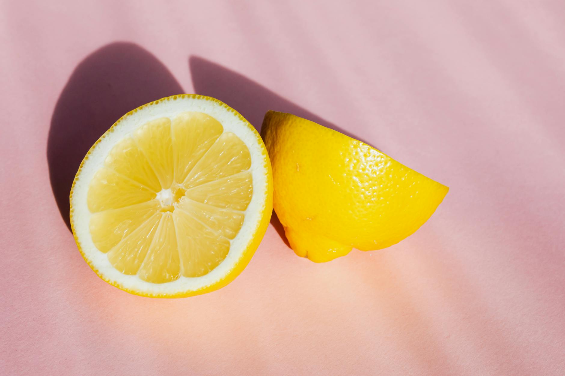 Fresh lemons on a pink background, symbolizing natural pleasure and vitality