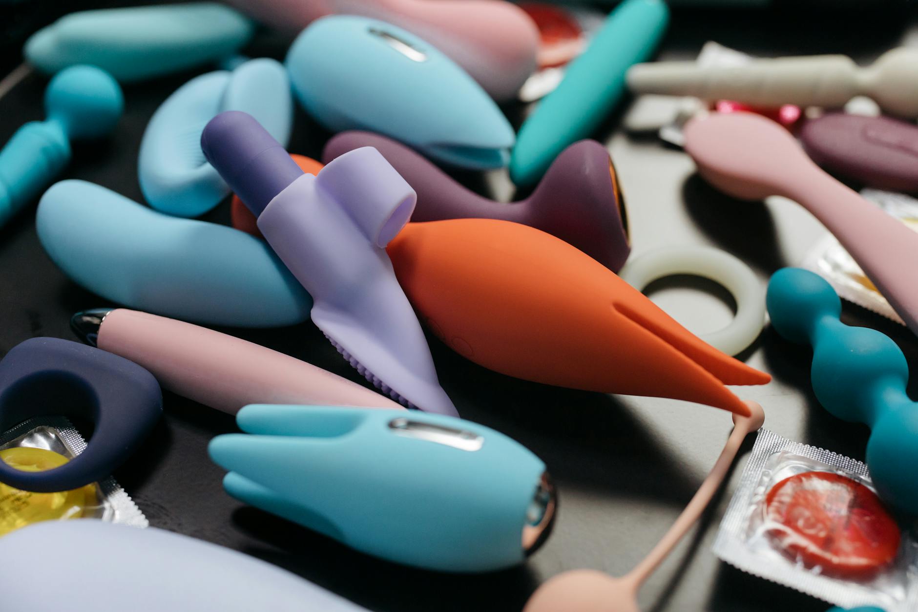 A blue silicone clitoral vibrator held in hand against a purple background, promoting self-care and pleasure.