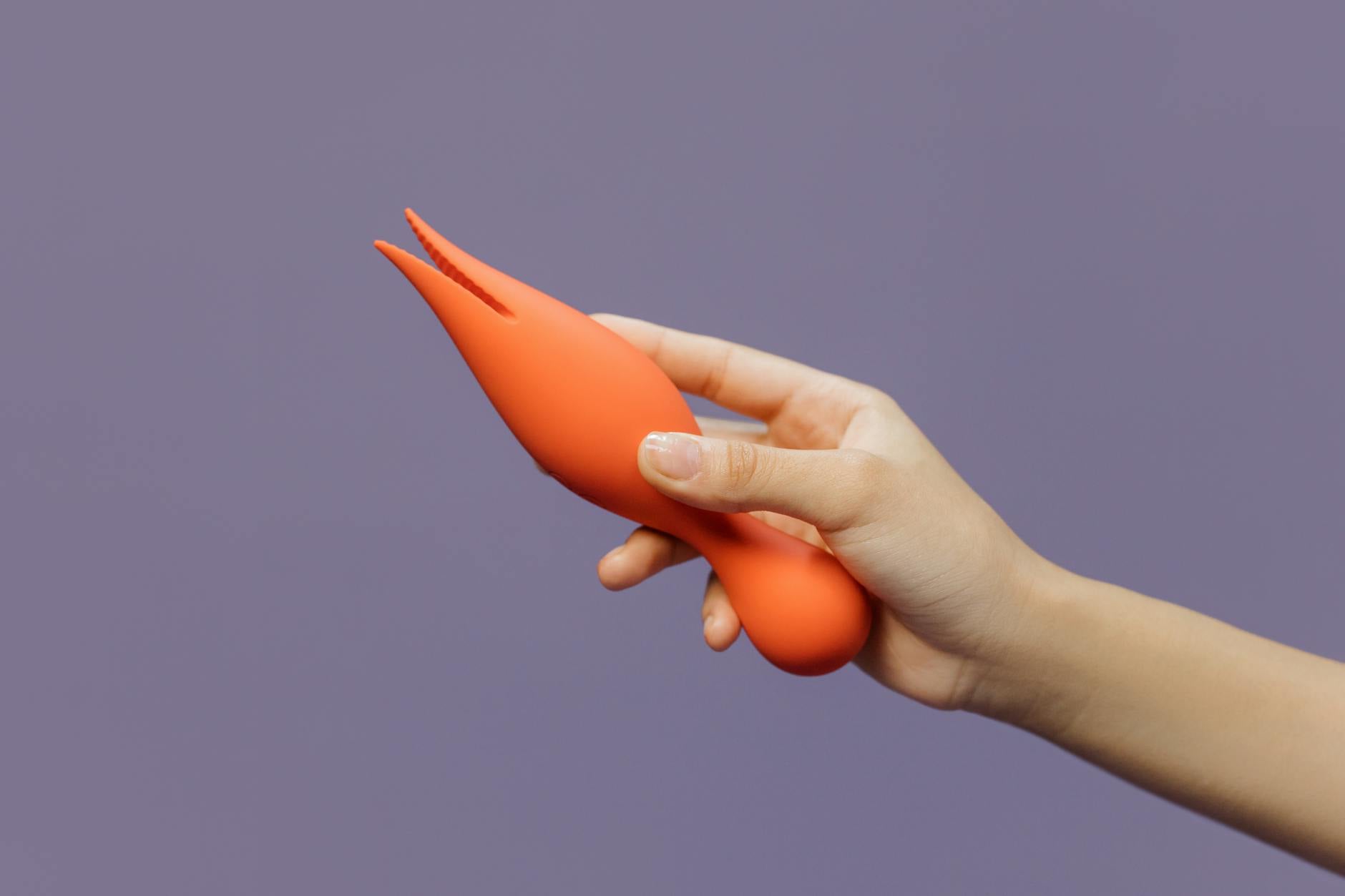Close-up of a hand holding a lemon vibrator against a purple backdrop, representing the journey back to sensation